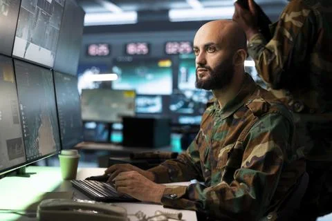 Army operator typing on PC keyboard, doing operational planning Stock Photos