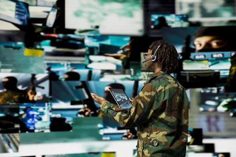 Army operator uses tablet and headset to manage secure military communications Stock Photos