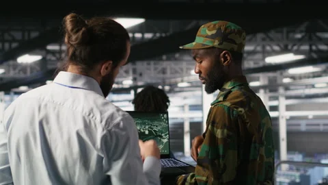 Army operators in data center using laptop to run drone control software Stock Footage 310277699