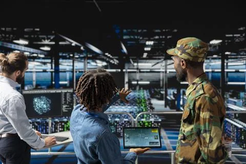 Army operators in server hub using device to run drone control software Stock Photos