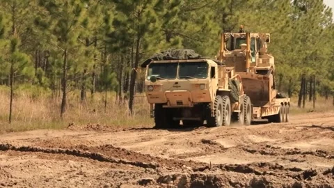 Army Oshkosh low-loader transporting bulldozer on sand road 動画素材 271338512
