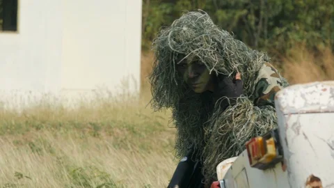 Army sniper walking through grass Video stock 85673976