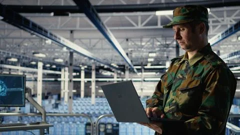 Army software developer in server hub uses artificial intelligence app on laptop Stock Photos