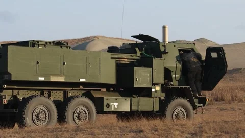 Army soldier climbs into the cab of a M142 HIMARS Stock Footage 334702287