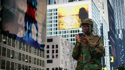 Army soldier examines smartphone map app and walking on city street Stock Footage 334169900