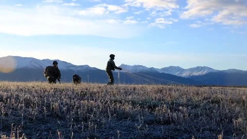 Army soldier pulling parachute in toward him after landing Stock Footage 288319654