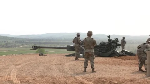 Army soldier pulls trigger and fires M777 Howitzer Stock Footage 257553329