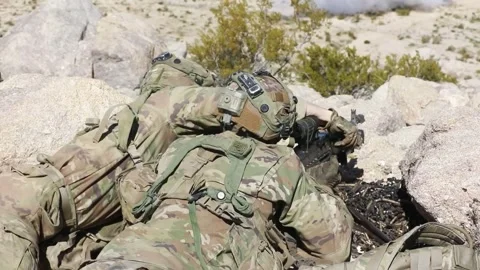 Army soldier reloading weapon in desert terrain Stock Footage 268824035