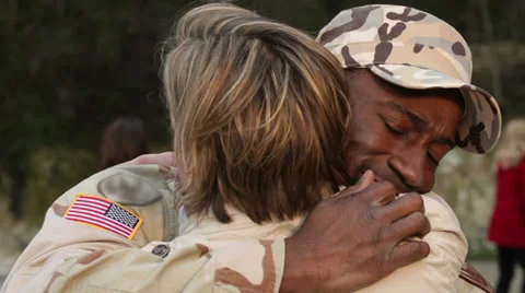 Army soldier returning home to the embrace of his wife Stock Footage
