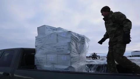 Army soldier unloading boxes of supplies from pickup truck in Arctic landscape Stock Footage 293684854