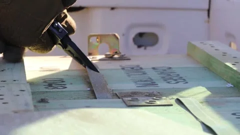 Army soldier using pliers to cut metal strap on box of explosives Stock Footage 261512682