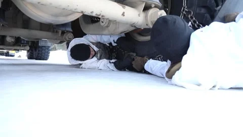 Army soldiers fitting snow chains to tyre of military truck Stock Footage 260312722