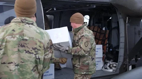 Army soldiers loading boxes of food supplies onto a UH-60 Black Hawk helicopter Video stock 293684855