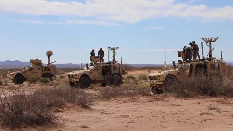 Army soldiers loading MK 19 grenade launchers on Oshkosh JLTV's in the desert Stock Footage 266894292
