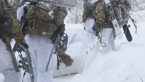 Army soldiers pulling a sled as they trek through snowy terrain Stock Footage 262530347