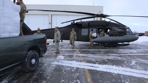 Army soldiers unloading boxes of supplies from pickup truck to UH-60 Black Hawk Stock Footage 293684856