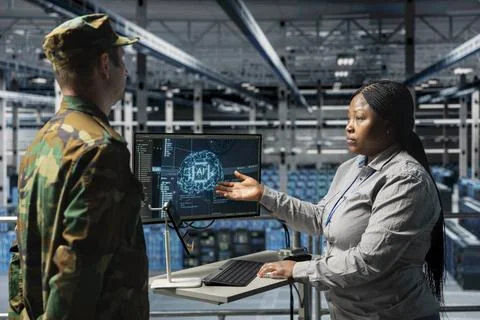 Army tech expert in data center relaying AI battlefield analysis to officer Stock Photos