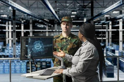 Army tech expert in data center presenting AI models analysis to commander Stock Photos
