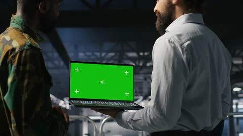 Army tech specialist in data center and coworkers using green screen laptop Foto stock