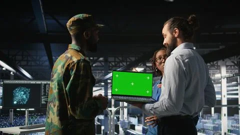 Army tech specialist in data center and coworkers using green screen laptop Stock Photos