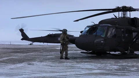 Army UH-60 Black Hawk taxiing on snow covered airfield with skids attached Stock Footage 293684784