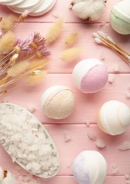Aroma bath bombs in spa composition with dry flowers and salt on pink backgro Stock Photos