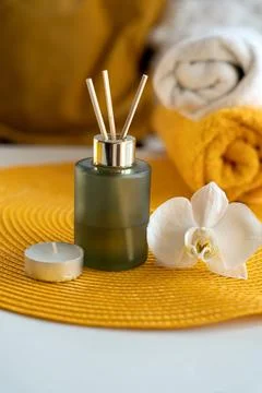 Aroma diffuser bottle with orchid flower on orange carpet and blurred backgro Stock Photos