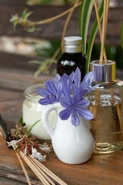 Aroma diffuser on rustic table with light blue and white flowers Stock Photos