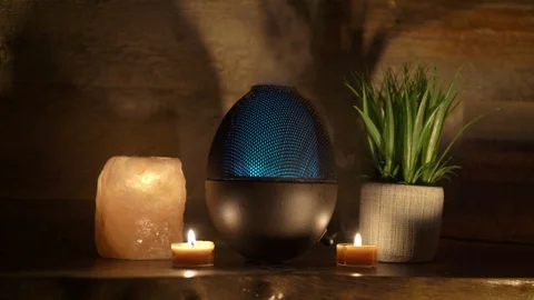 Aroma electric oil diffuser lamp, candles on wooden table in room. Stock Footage 129298725