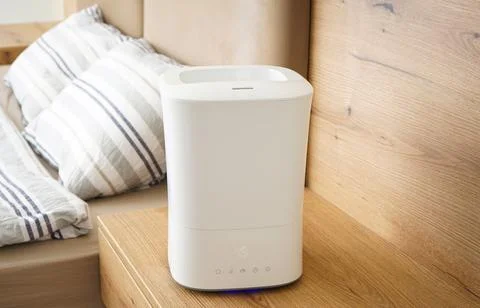Aroma oil diffuser on the bedside table, steam from the air humidifier. Ultra Foto stock