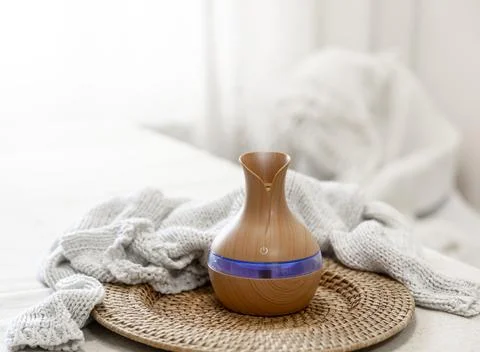 Aroma oil diffuser lamp on a blurred background. Stock Photos