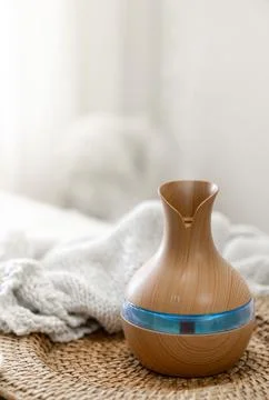 Aroma oil diffuser lamp on a blurred background. Stock Photos