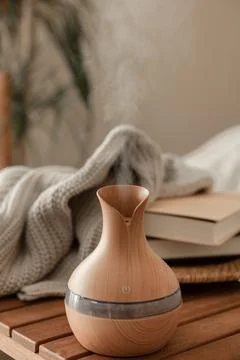 Aroma oil diffuser lamp on a blurred background in the interior of the room. Stock Photos