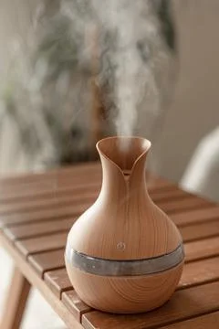 Aroma oil diffuser lamp on a blurred background. Stock Photos