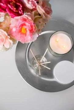 Aroma reed diffuser, candle and flowers on table Stock Photos