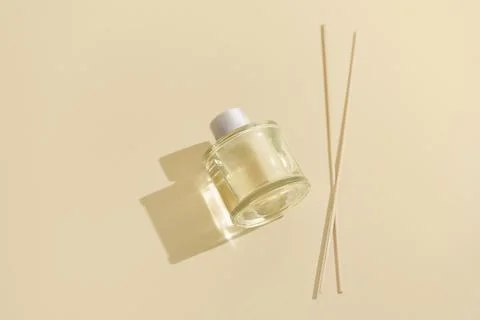 Aroma reed diffuser clear glass bottle for home and rattan sticks on beige .. Stock Photos