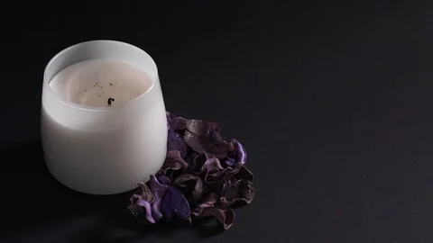 Aromatherapy concept - a woman's hand sets fire to a white candle isolated on a Stock Footage 124713777