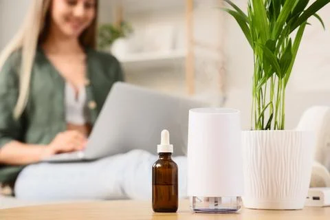 Aromatherapy diffuser and essential oil bottle on a wooden table with a blurr Stock Photos
