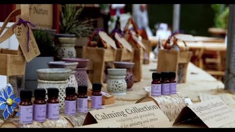 Aromatherapy essential oils and diffusers displayed at an outdoor market stall Stock Footage 326369526
