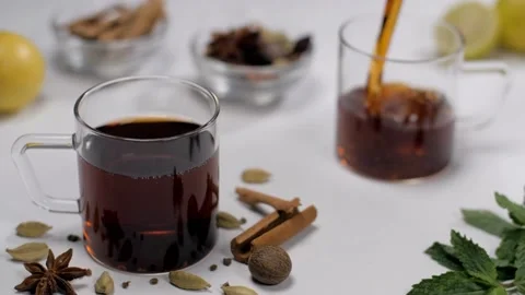 Aromatic black spicy tea falling in a transparent cup - traditional Indian be... 스톡 동영상 153070652