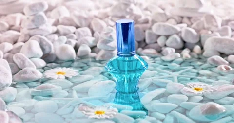 Aromatic blue perfume in environment of white stones and sea. Vidéo 340300782