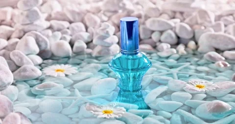 Aromatic blue perfume in environment of white stones and sea. Vídeo Stock 346556875