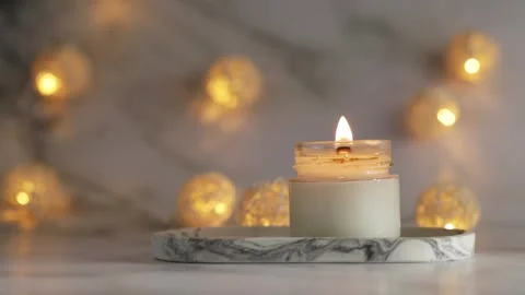 Aromatic burning candle on marble tray with warm lights, cozy minimalist de.. Stock Footage 252380671