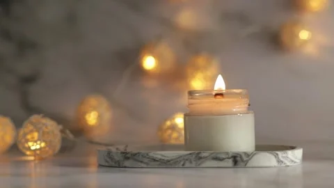 Aromatic burning candle on marble tray with warm lights, cozy minimalist de.. Stock Footage 252962214