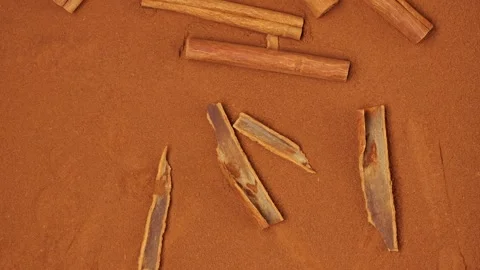 Aromatic cinnamon sticks lying on brown powder Stock-Footage 326220712