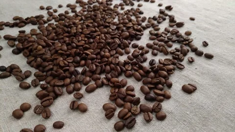Aromatic coffee beans are randomly scattered on a textile napkin, in a slow Video stock 150907360