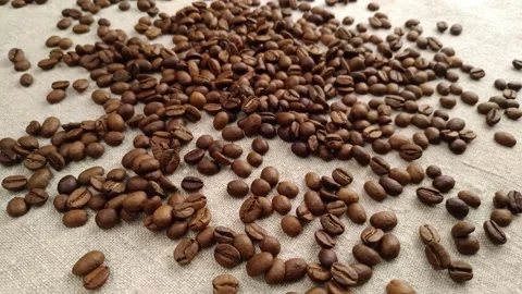 Aromatic coffee beans are randomly scattered on a textile napkin, in a slow Video stock 150907383