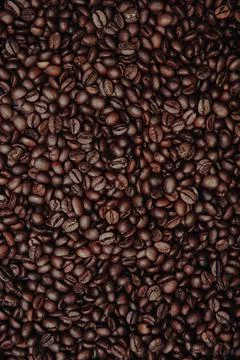 Aromatic coffee beans with background. Vertical image Stock Photos