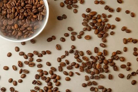 Aromatic coffee beans scattered on a smooth surface in a cozy kitchen Stock Photos