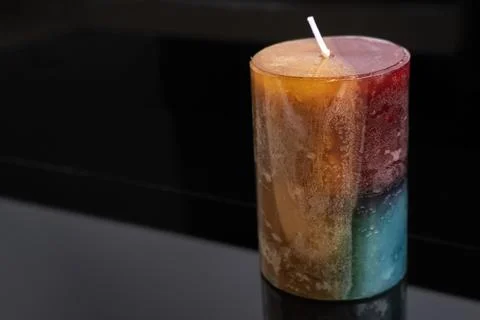 Aromatic colored decorative candle on a dark background, aromatherapy Foto stock